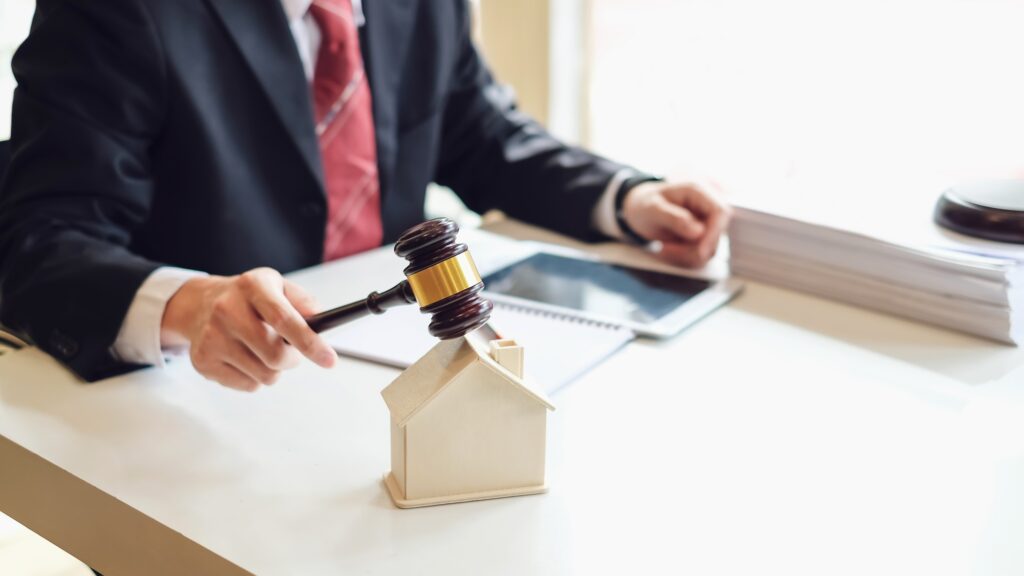 Lawyer holding a hammer at the property auction house at the office.