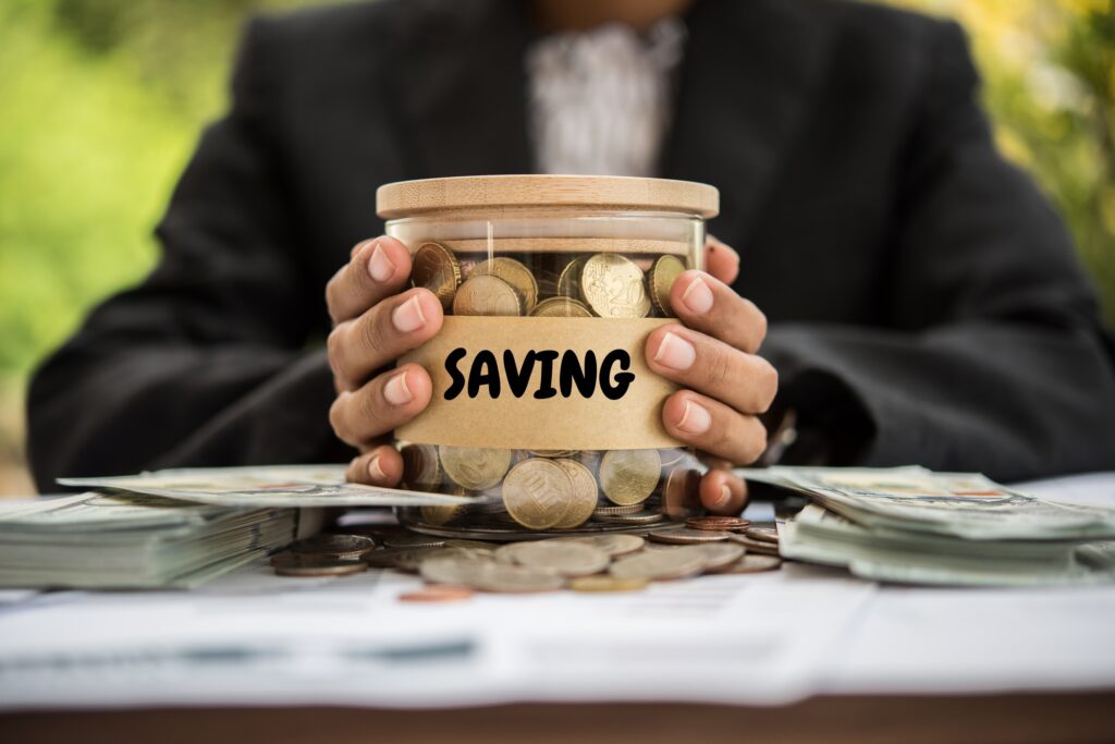 Saving Money putting coins into a jar.